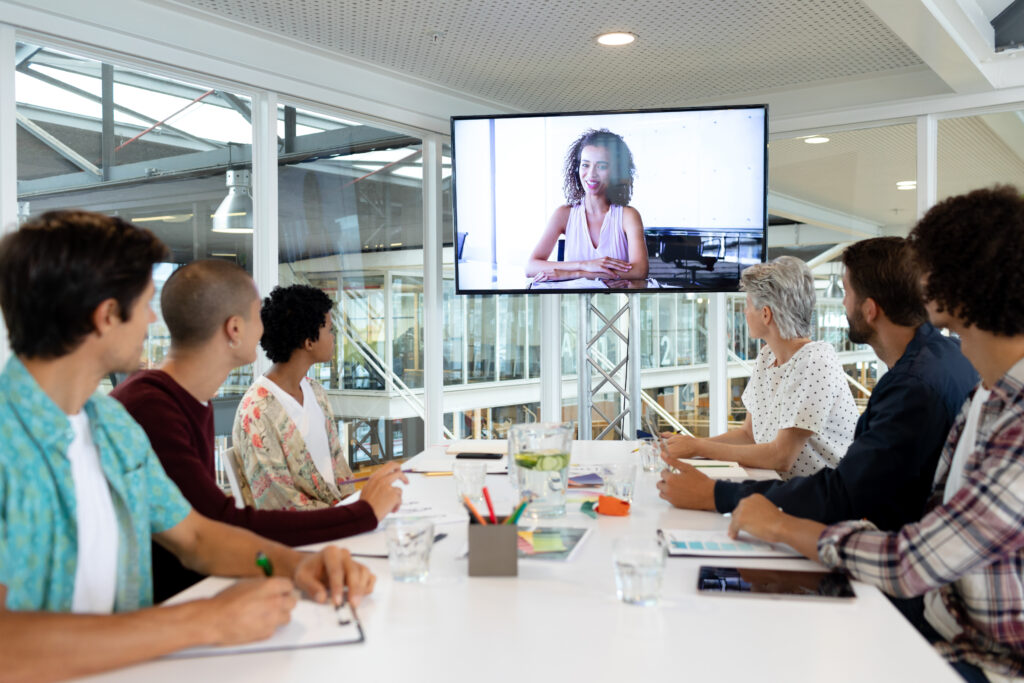 Side view of diverse business people attending video conference at conference room in a modern office