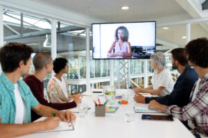 Side view of diverse business people attending video conference at conference room in a modern office